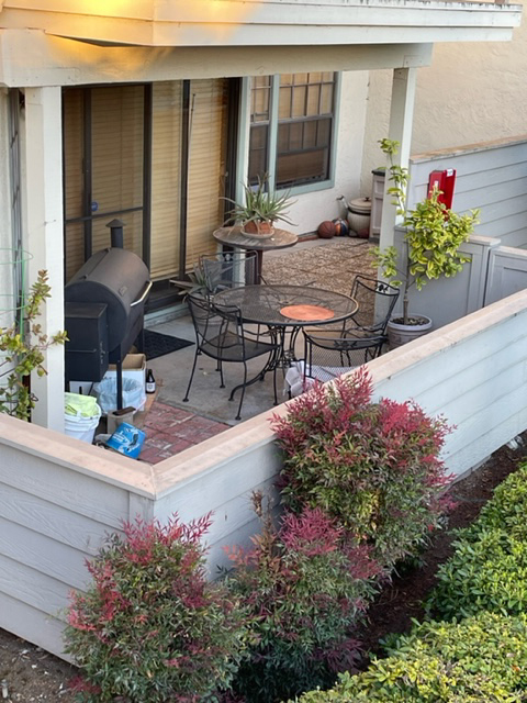 A barbeque is up against a residential building wall, in violation of the 2019 California Fire Code